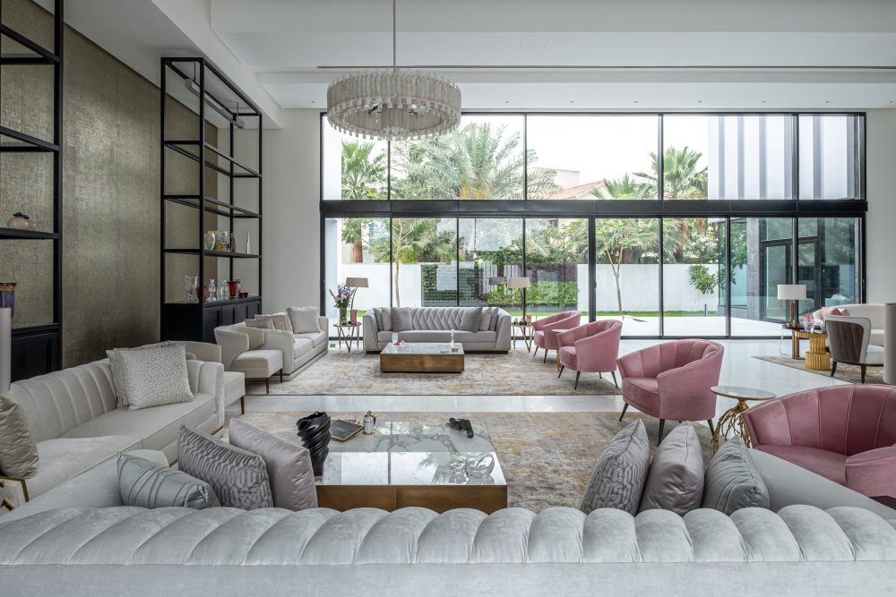 Large living room with a mirror wall, a sofa, armchair and coffee table.