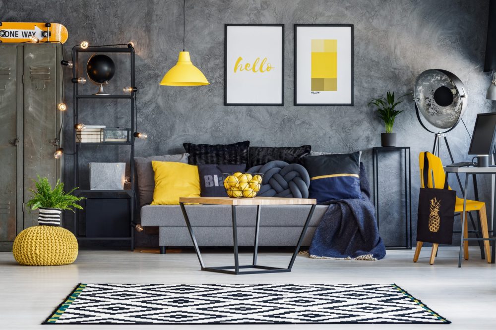 Black and yellow living room with sofa, a coffee table and a table with a chair to work.
